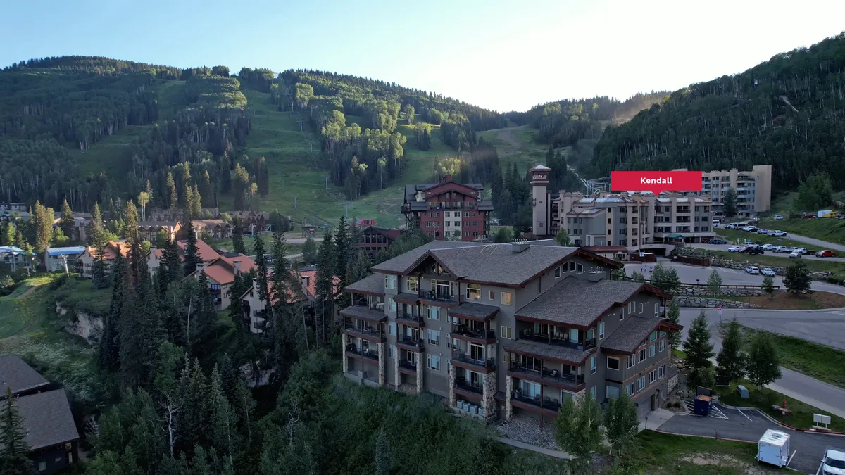 A panoramic view of the mountain landscape, showcasing ski resorts, wooded areas, and cozy buildings. The peaceful scenery suggests proximity to hiking trails and mountain activities, with inviting lodging at the heart of it all.